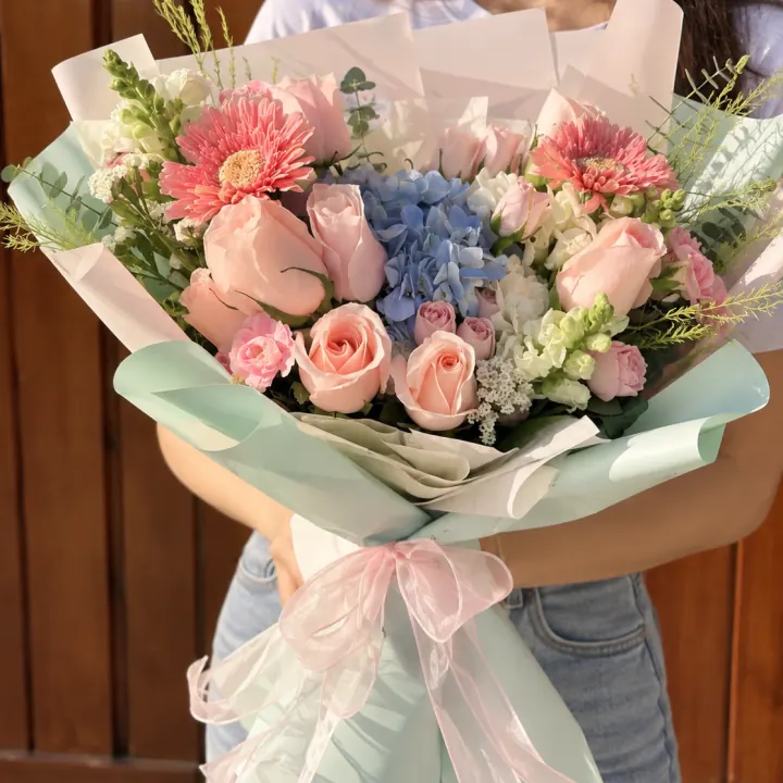 Ramo estilo jardín en tonos pastel con lazo rosa